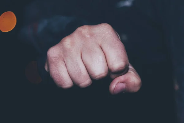 Fist. night. The concept of street violence in the house. after him the flashlight is out of focus. — Stock Photo, Image