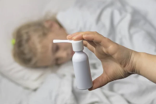 Seorang gadis dengan rambut putih berbaring di tempat tidur. ibu menggunakan inhaler membuat suntikan di tenggorokan pasien . — Stok Foto