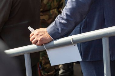 Gün ışığı. Erkek elinde metal bir korkuluk var. Küçük bir şişede antiseptik var..