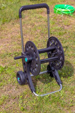 Gün ışığı. Çimlerin üzerinde bir hortum arabası var. yakın plan.