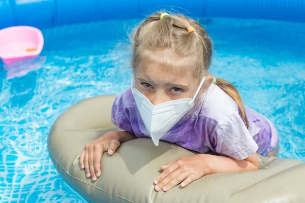 a small pool of blue color. A girl with white hair bathes in it.