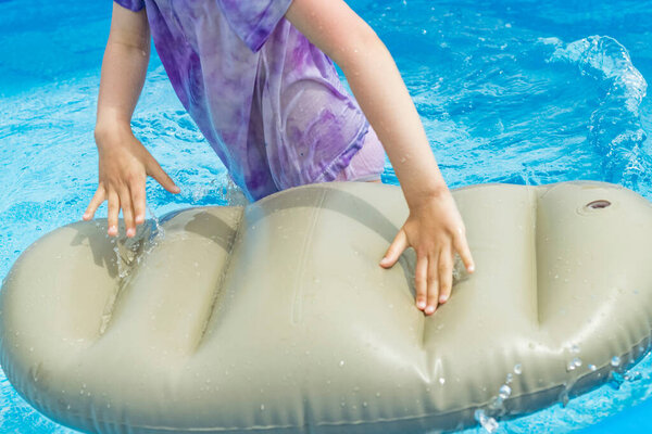 Маленький бассейн голубого цвета. Девушка с белыми волосами купается в ней
.