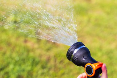 Gün ışığı kızı ellerinde su tutuyor ve bir su akıntısı püskürtülüyor. Yakın plan..