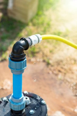 Parlak ışık. Suyun altında iyi donanımlı. PVC boruları mavi. Yakın plan..