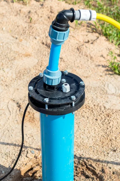 Bright lighting. equipped well under water. Their PVC pipe is blue. Close-up — Stock Image Bright Lighting Equipped Well Water Pvc Pipe Blue Close Stock Image