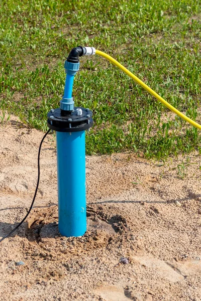 Bright lighting. equipped well under water. Their PVC pipe is blue. Close-up — Stock Image Bright Lighting Equipped Well Water Pvc Pipe Blue Close Royalty Free Stock Photos