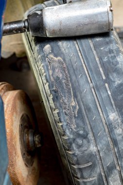 Atölye. Özel bir aletle araba tekerleğinden çıkarılmış. Lastikte çok fazla yıpranma ve hasar var..