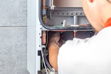 Usta duvara bir gaz maskesi yerleştirir ve ağırlığını duvara verir. Ön torpido gözü açık. Çöp temizleme, temizlik, tasfiye. Yakın plan..