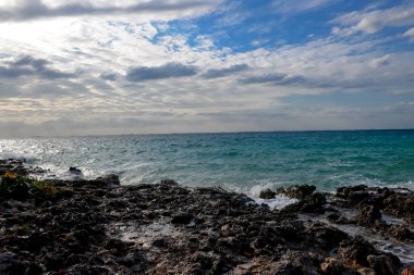 Deniz kumlu sahilde dalgalar halinde dalgalanıyor. Gün ışığı.
