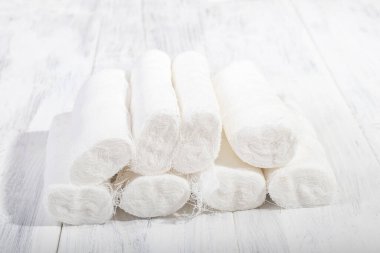 Üzerinde retro tarzı beyaz ahşap bir arka plan var. Bir yığın tıbbi bandaj, piramit şeklinde.