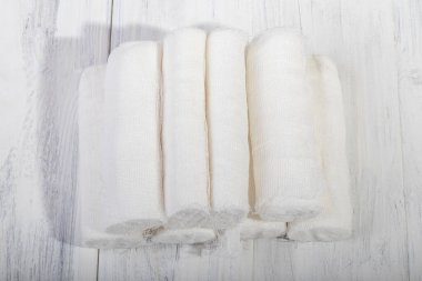 Üzerinde retro tarzı beyaz ahşap bir arka plan var. Bir yığın tıbbi bandaj, piramit şeklinde.