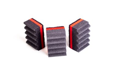 Kırmızı çizgili ve kıvrımlı yüzeyi olan siyah köpük kauçuktan yapılmış bulaşıkları yıkamak için süngerler. Yakın plan. İzole et