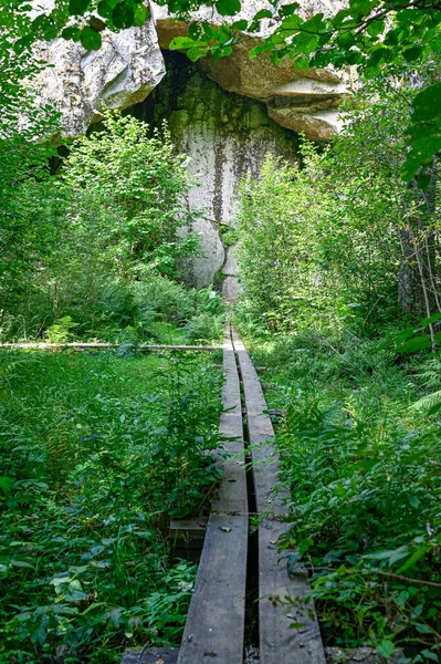 Passerelle en bois menant à une grande roche — Photo