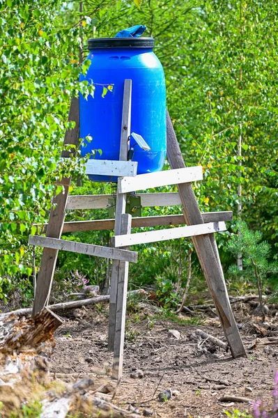 Dispensador de alimentos de barril azul en el bosque para alimentar a los animales salvajes — Foto de Stock
