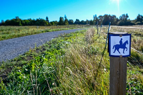 gravel path with sign of person riding a horse