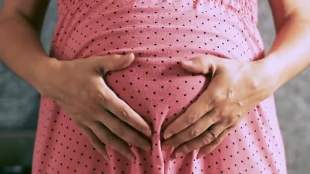 穿着粉红色的怀孕女孩抚摸她的肚子 — 图库视频影像