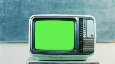 80 lerin bir okulda yeşil ekran televizyon. Dolly dışarı. Yakın çekim. Herhangi bir görüntü veya resim ile yeşil ekran değiştirmek hazır olmasını istiyorum. Adobe After Effects veya diğer video düzenleme yazılımı girme (Chroma Key) etkisi ile yapabilirsin. Full Hd. 
