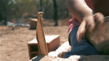 Tuğlalar, bir tencere ve tahta bir sopa ile araç sürücüsü oynayan çocuk.