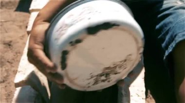 Tuğlalar, bir tencere ve tahta bir sopa ile araç sürücüsü oynayan çocuk.