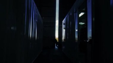Sunset 'te konteyner deposunun kapısını açan adam. İşe Dönüş Konsepti. 
