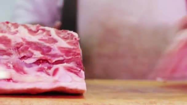 白いゴム手袋と肉屋のカウンターで赤肉を切断するブッチャー クローズアップ — ストック動画