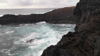 Ana Kai Tangata Mağarası 'nın önündeki Kayalıklarda Dalgalar Kırılıyor Rapa Nui' de Hanga Roa 'ya yakın, Paskalya Adası, Şili, Pasifik Okyanusu. 