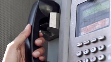 Arjantin 'in Buenos Aires caddesinde eski bir telefon kulübesini kullanan genç bir kadının elleri. Yakın plan.   