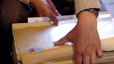 La Paz / Bolivya - 09 09 09 2019: Bolivya 'daki Müzik Enstrümanları Müzesi' nde Notalar ve Müzik Sayfaları ile Bir Kitap Tutan Erkek Eller. Yakın plan.  