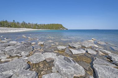 Sakin suları ve uzak bir göl kıyısındaki göl Huron Bruce Yarımadası Milli Parkı'nda Ontario üzerinde buzlu