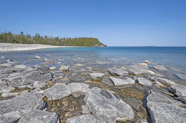 Sakin suları ve uzak bir göl kıyısındaki göl Huron Bruce Yarımadası Milli Parkı'nda Ontario üzerinde buzlu