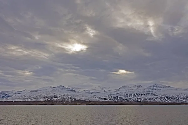 太阳试图冲破 Vaigat 海峡西格陵兰沿岸山区 — 图库照片