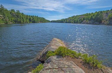 Ormanda Killarney Provincial Park Ontario Gölü üzerinde güneş parıldıyor
