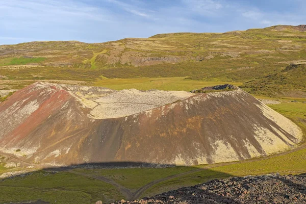 Kleiner Krater, der in einer Vulkanlandschaft aus dem Schatten steigt — Stockfoto