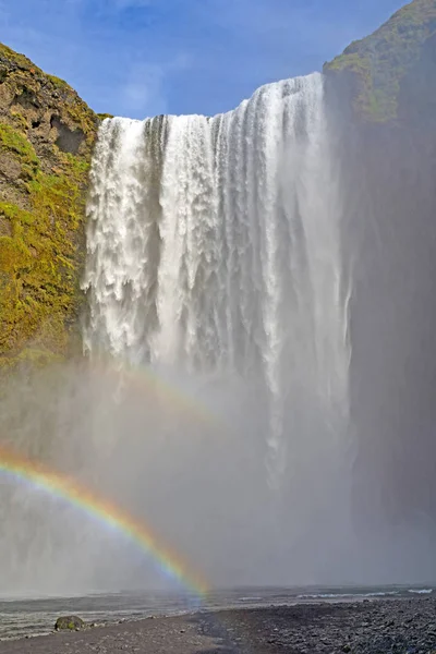 Colorido Skogafoss cae por encima de un arco iris — Foto de Stock
