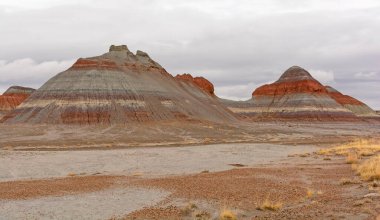 Lonely Buttes in the Cloudy Desert in Petrified Forest National Park in Arizona clipart
