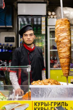 Moskova, Rusya - 23 Mayıs 2018: Satıcı ve aşçı, ızgara tavuk ve shawarma metro çıkışında işlek bir yerde küçük bir sokak dükkanında. Izgara tavuk hızlı bir akşam yemeği yüksek talep olduğunu.