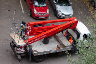 Moskova, Rusya - 3 Eylül 2018: Hidrolik Asansör ile bir araba Da-324 Chaika servisin bir konut bina avluda bitki. Kuru dallar, zarar gören ağaç, kesme budama kroning