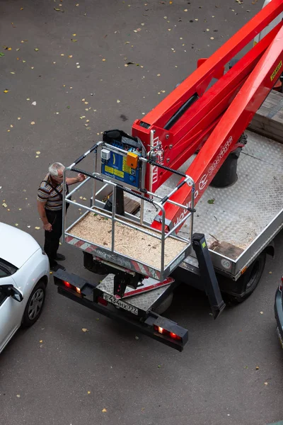 Moskova, Rusya - 3 Eylül 2018: Hidrolik Asansör ile bir araba Da-324 Chaika servisin bir konut bina avluda bitki. Kuru dallar, zarar gören ağaç, kesme budama kroning