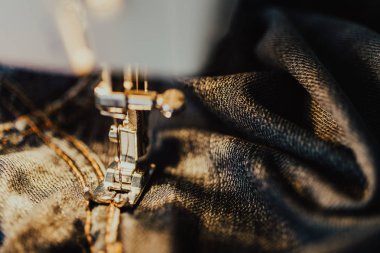 Kot dikiş makinesi tamir. Kumaş, iğne ve iplik görünümü. Yerleşik akkor lamba aydınlatma. Kot pantolon, genellikle kot veya dungaree kumaştan yapılmış bir türüdür