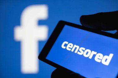 Moskova, Rusya - 14 Eylül 2018: el sansürlü metin görüntüleyen bir smartphone. Logo Facebook arka plan bulanık. Popüler sosyal ağlar üzerinde sansür kavramını. Sığ Dof