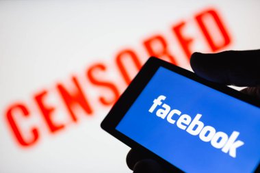 Moskova, Rusya - 14 Eylül 2018: Smartphone el Facebook logo görüntüleme. Kırmızı sansürlü metin arka plan bulanık. Popüler sosyal ağlar üzerinde sansür kavramını. Sığ Dof