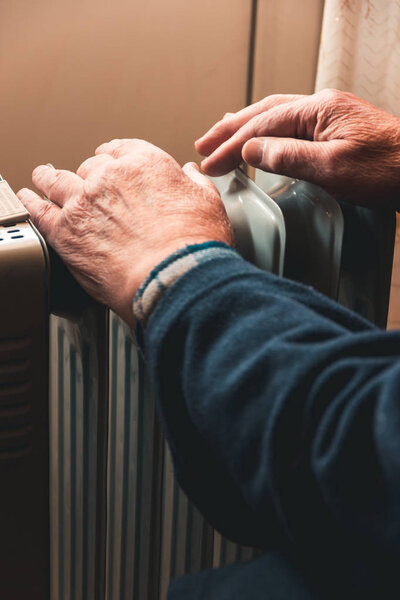 Пожилой человек греет руки над электрическим обогревателем. В межсезонье центральное отопление задерживается, поэтому людям приходится покупать дополнительные обогреватели, чтобы сохранить тепло в домах, несмотря на увеличение расходов на электричество.
.