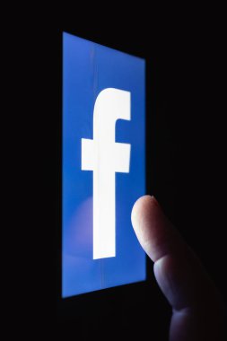 Moskova, Rusya - 14 Eylül 2018: Facebook logo görüntüleme Smartphone bir tablo karanlıkta yatarken. Parmak dokunmatik ekran üzerinde. Popüler sosyal ağ bağımlılığını kavramı