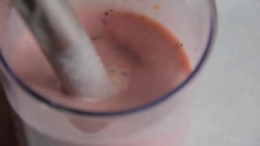 Paslanmaz çelik çubuk blender ile güler yüzlü kokteyl hazırlama şeffaf plastik bir fincan meyve ve sebze hazırlanması için malzemeler ile daldırma, süt, yoğurt, meyve suyu, bal, fındık ekledi