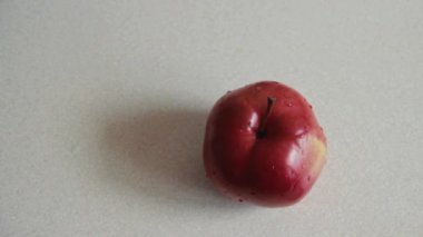 Erkek sol el Kırmızı elma su damlacıkları ile tablosundan alır. Vegan meyve öğle yemeği için seçin. Yukarıdan görüntüleyin. Düz yatıyordu.