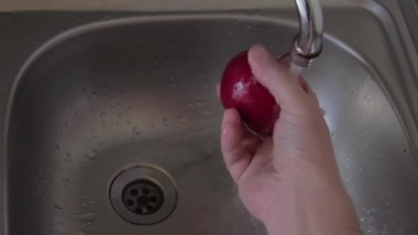 一个人在自来水下摩擦和洗一个成熟的红苹果 素食准备小吃 右手与水果在厨房水槽下面的水流 从上面看 不锈钢餐具 — 图库视频影像