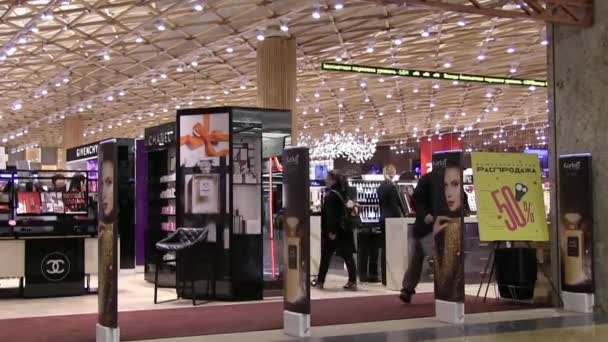 モスクワ ロシア連邦 2018 回された男は 大型ショッピング センターのモール内の化粧品店で盗難防止ゲートを通過 光と音のアラームがトリガーされます 未払い商品と紙袋 — ストック動画