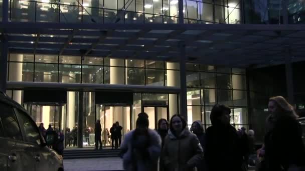 俄罗斯莫斯科 2018年1月26日 人们在莫斯科摩天大楼入口处附近的街道上吸烟 将玻璃门旋转到商务中心 办公室窗户上的灯光 — 图库视频影像