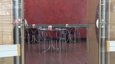 Panorama ve yakınlaştırma giriş kapıları ve katta ve mobilya modern kantin aperatif bar. Laminat ve çelikten sandalye ve masa biber ve tuz kavanoz. Peçete standında. Yeşil çizgili kırmızı duvar