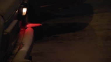 Eski bir benzinli araba gece ışıklar Park içinde belgili tanımlık soğuk kışın motoru ısıtır. Beyaz zehirli duman puffs dışarı egzoz borusu. Egzoz kirliliği. Küresel ısınma. Karlı sokak